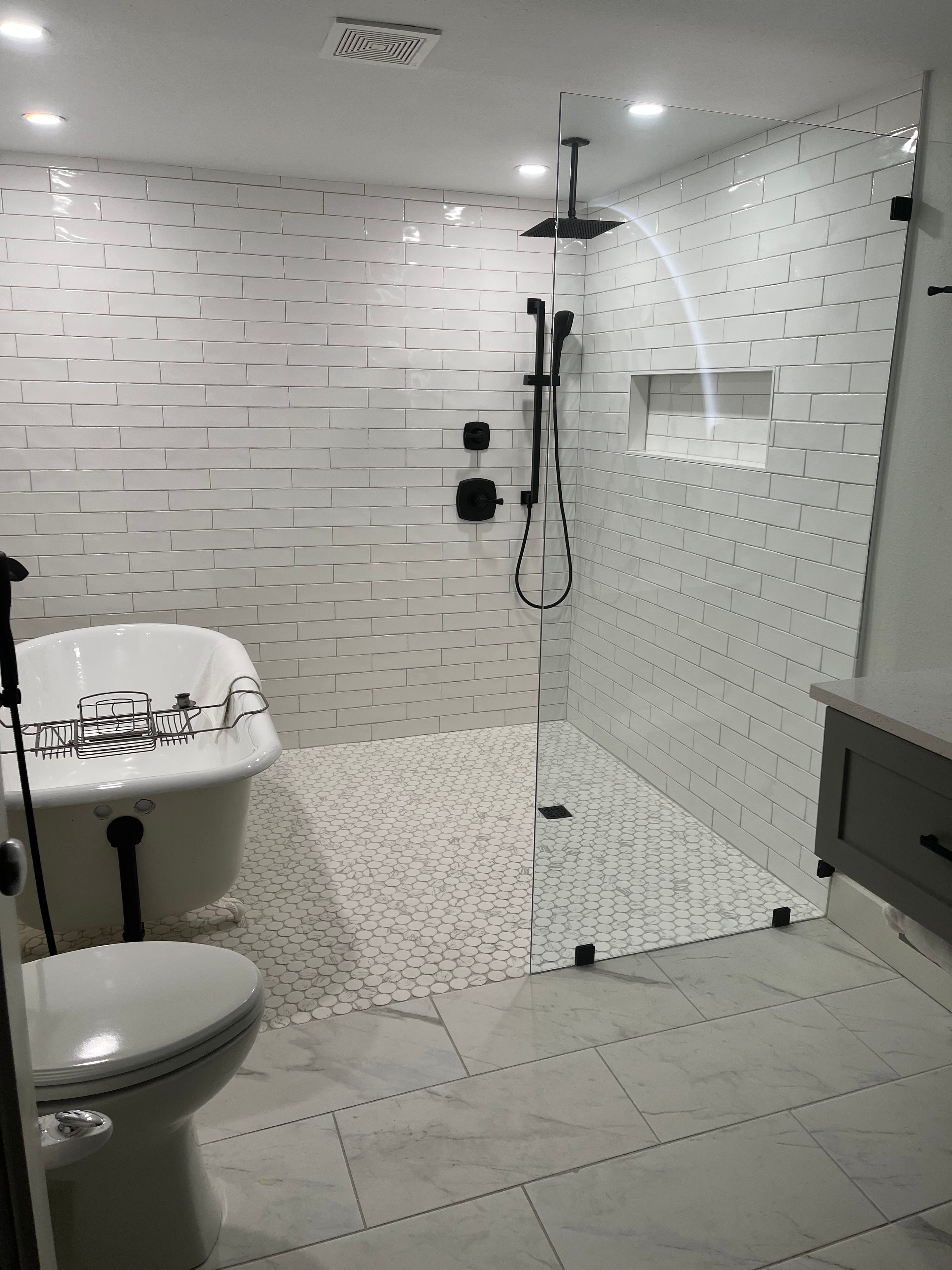 Custom bathroom with white subway tile, freestanding tub, and matte black fixtures