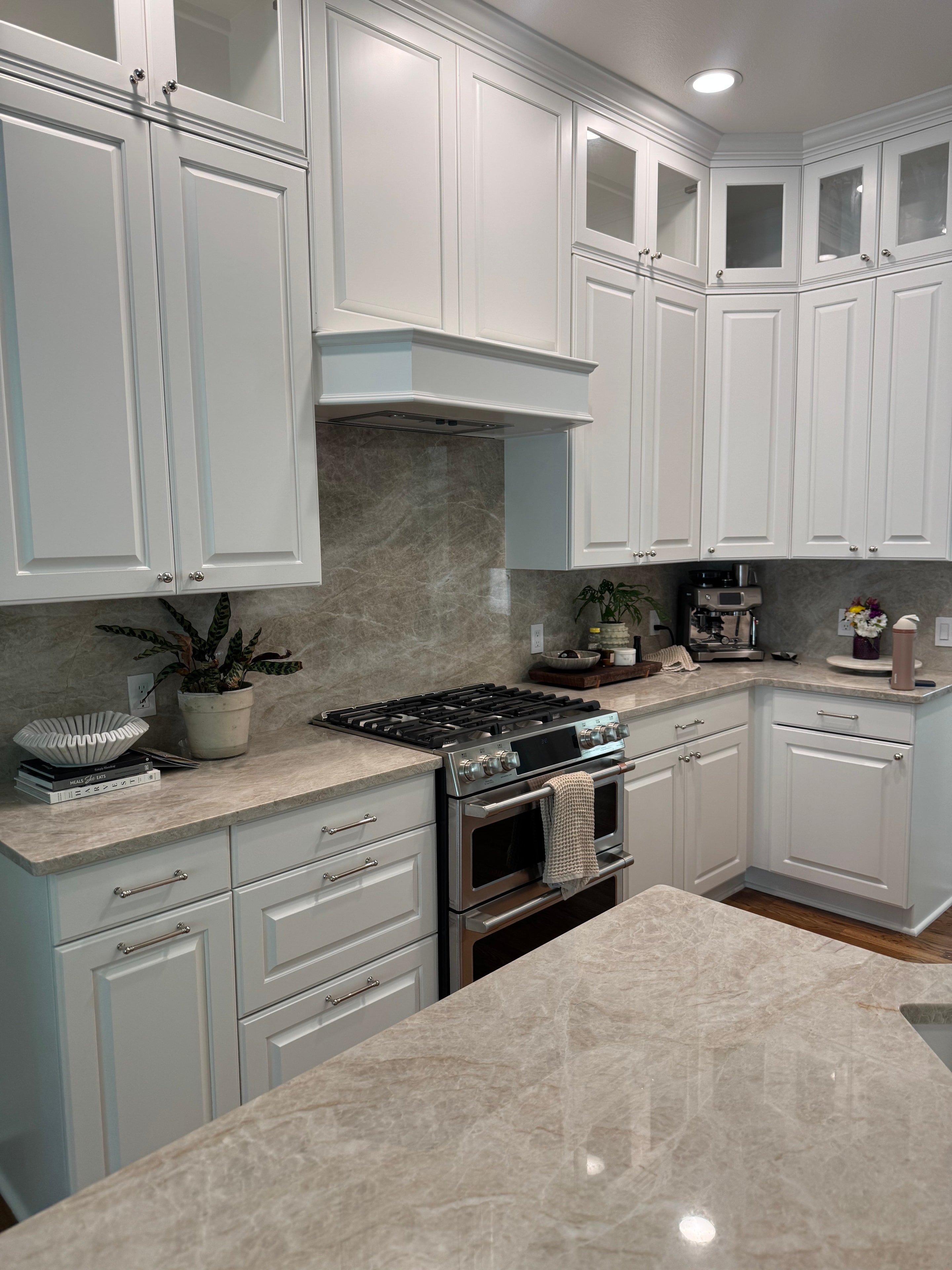 Kitchen remodel with white shaker cabinets, marble tile floor, and professional range