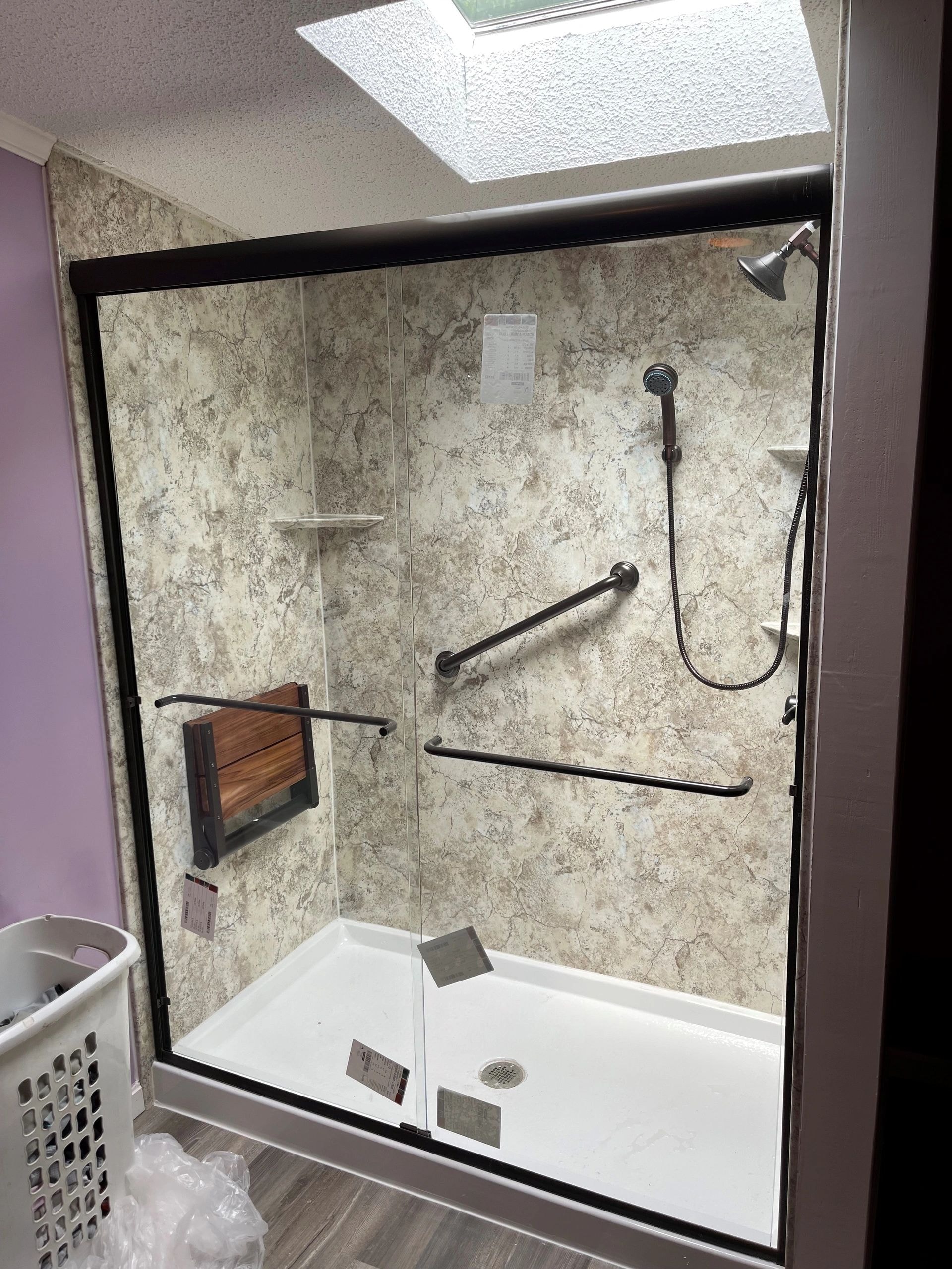 Njuguna bathroom after renovation — shower enclosure with grab bars by BMW Renovations
