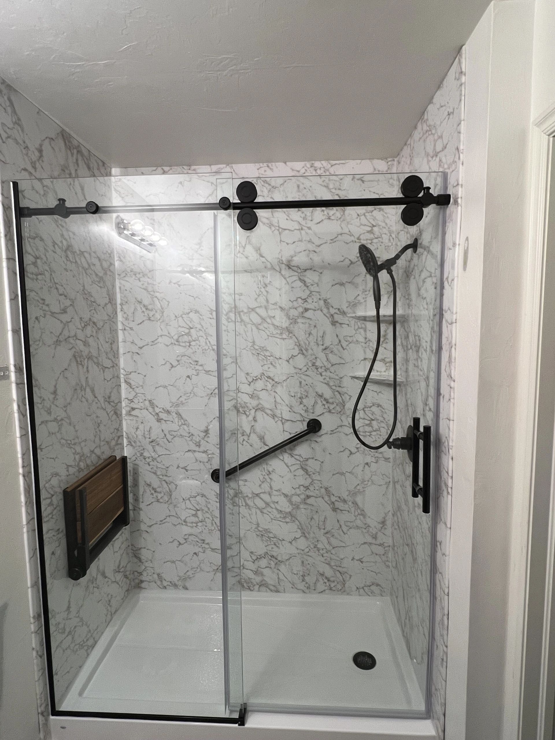 Stefanie bathroom after — shower enclosure with black metal sliding glass door